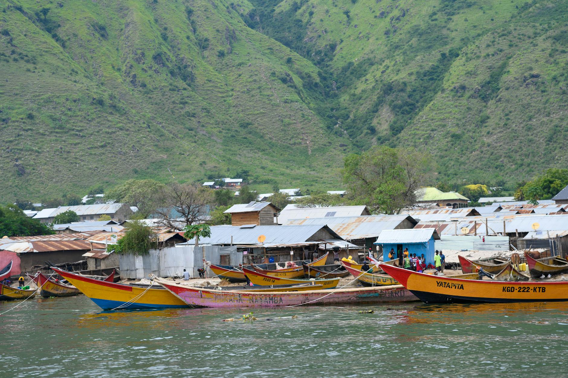 colorful fishing boats near lakeside village